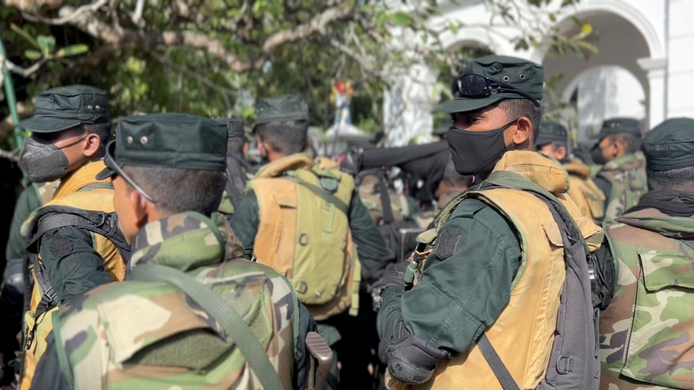 Members of the security force stand guard as people protest at Sri Lanka's Prime Minister Ranil Wickremesinghe's office, amid the country's economic crisis, in Colombo, Sri Lanka July 13, 2022 in this still image obtained from a social media video. Marlon Ariyasinghe/via REUTERS