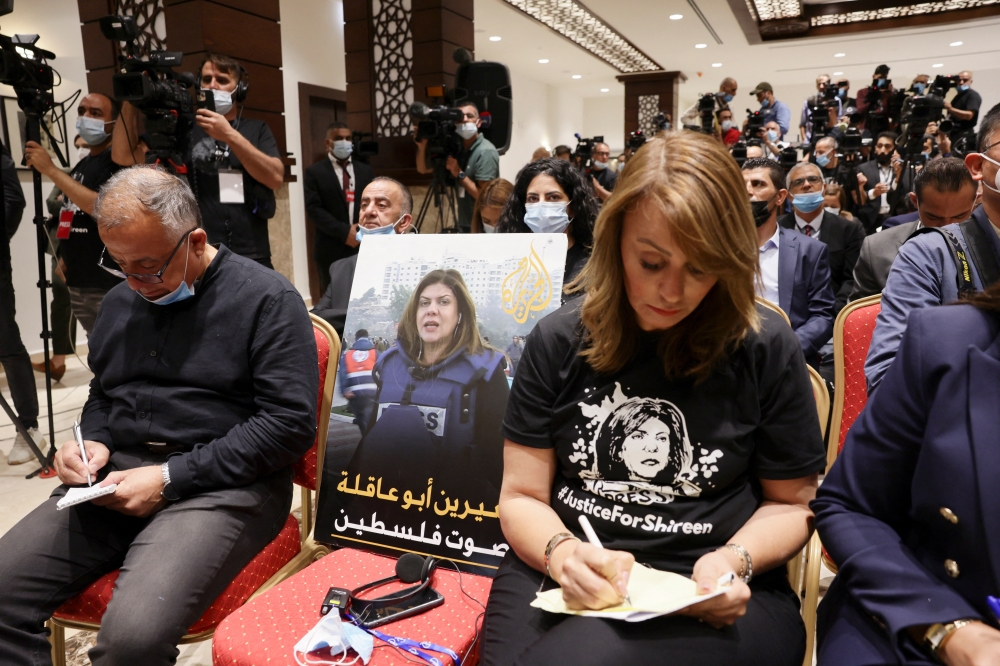 An image of slain Palestinian-American journalist Shireen Abu Akleh is placed on a chair, at a Palestinian President Mahmoud Abbas and US President Joe Biden news conference, in Bethlehem on July 15, 2022. (REUTERS/Evelyn Hockstein)