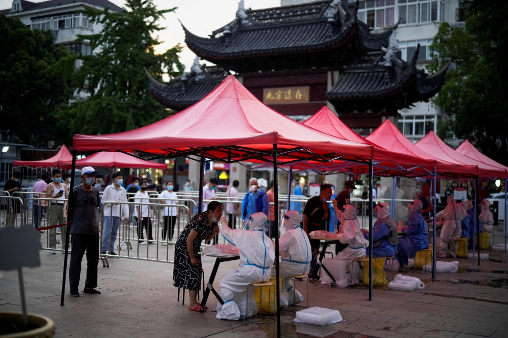 People line up to get tested for the coronavirus disease (COVID-19) at a nucleic acid testing site, following the coronavirus disease (COVID-19) outbreak, in Shanghai China July 12, 2022. REUTERS/Aly Song/File Photo