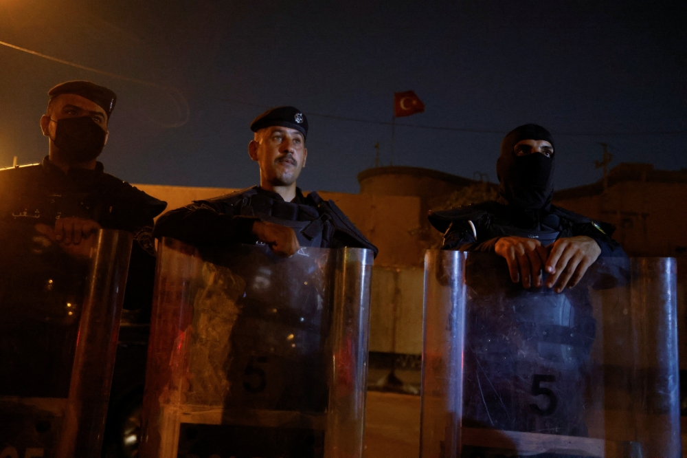 Police officers stand in front of a building belonging to the Turkish Embassy during a demonstration against an alleged Turkish attack on a mountain resort in Iraq's northern province of Dohuk, in Baghdad, Iraq July 20, 2022. (REUTERS/Ahmed Saad)