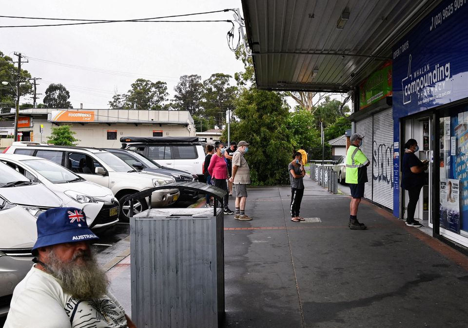 Customers queue outside a Western Sydney chemist to purchase Rapid Antigen Test kits in the wake of the coronavirus disease (COVID-19) pandemic in Sydney, Australia, January 5, 2022. REUTERS/Jaimi Joy

