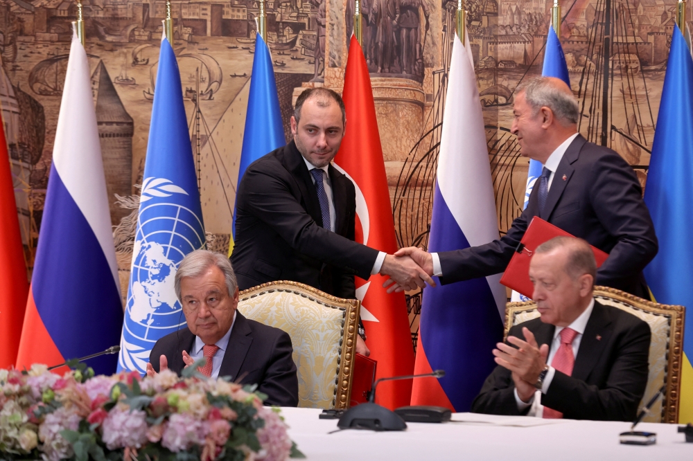 Ukrainian Infrastructure Minister Oleksandr Kubrakov and Turkish Defence Minister Hulusi Akar shake hands next to UN Secretary-General Antonio Guterres and Turkish President Recep Tayyip Erdogan during a signing ceremony in Istanbul, Turkey, July 22, 2022. (REUTERS/Umit Bektas)