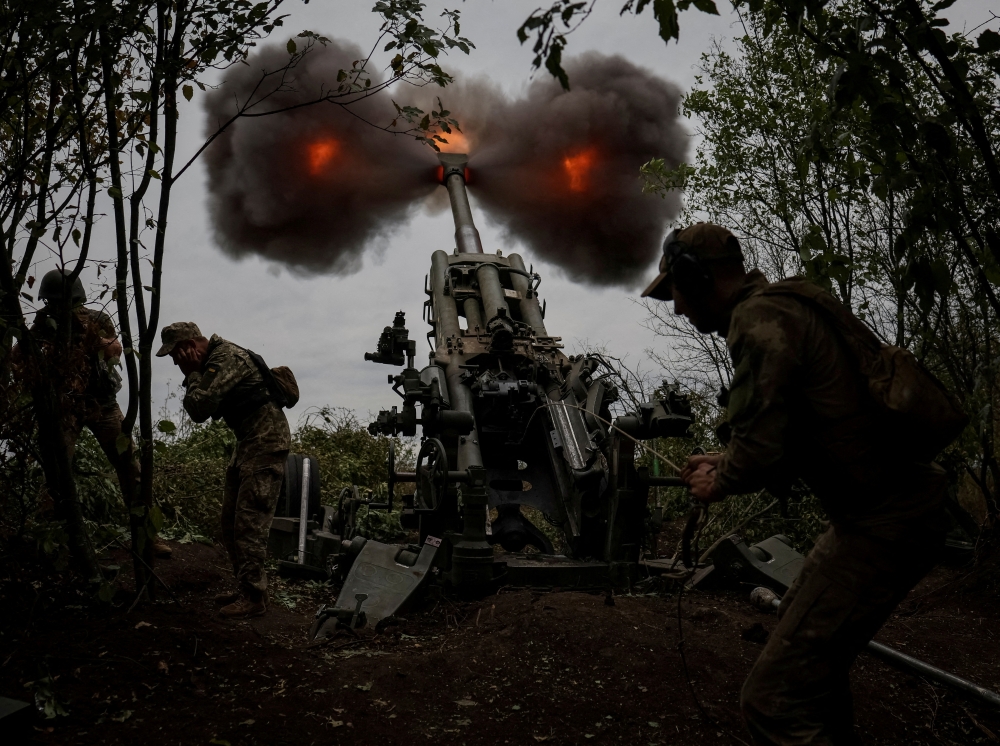 Ukrainian service members fire a shell from a M777 Howitzer at a front line, as Russia's attack on Ukraine continues, in Kharkiv Region, Ukraine, July 21, 2022. (REUTERS/Gleb Garanich)

