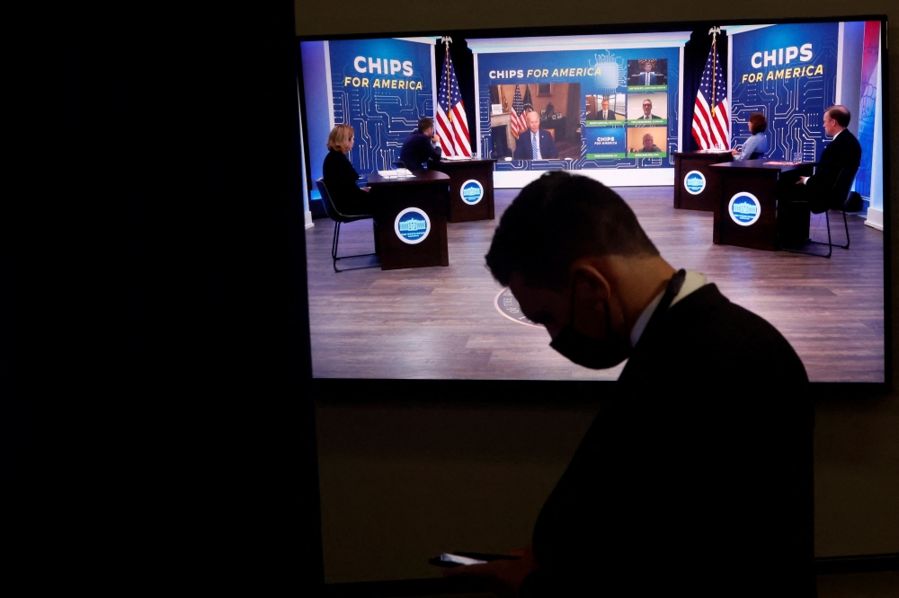 A White House press aide looks on as US President Joe Biden appears virtually in a meeting with business and labor leaders about the 'Chips Act' in an auditorium on the White House campus in Washington, US, July 25, 2022. (REUTERS/Jonathan Ernst)