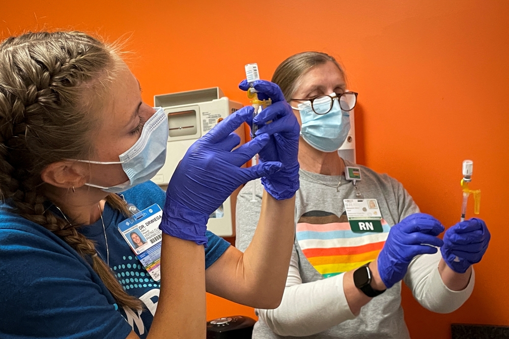 Dr Emily Drwiega from the University of Illinois Health and Maggie Butler, a registered nurse, prepare monkeypox vaccines at the Test Positive Aware Network nonprofit clinic in Chicago, Illinois, US, July 25, 2022. (REUTERS/Eric Cox)