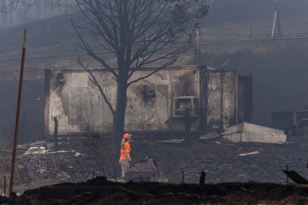 A member of a search and rescue team walks along an area destroyed by the McKinney Fire near Yreka, California, U.S., August 1, 2022. REUTERS/Carlos Barria