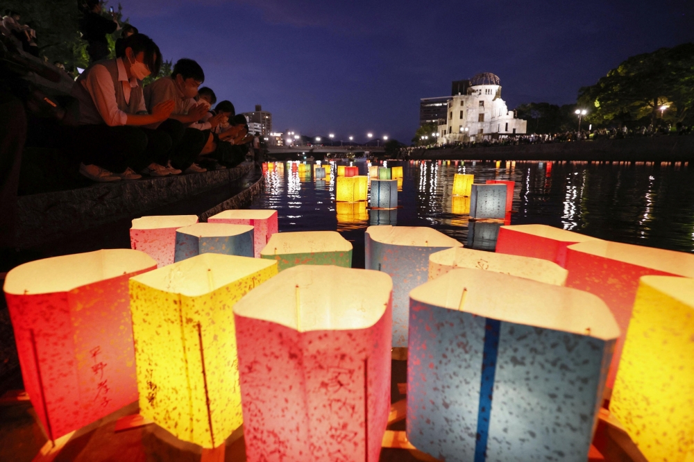 People release paper lanterns on the Motoyasu River facing the gutted Atomic Bomb Dome in remembrance of atomic bomb victims on the 77th anniversary of the bombing, in Hiroshima, Japan August 6, 2022, in this photo taken by Kyodo. Mandatory credit Kyodo via REUTERS ATTENTION EDITORS 
