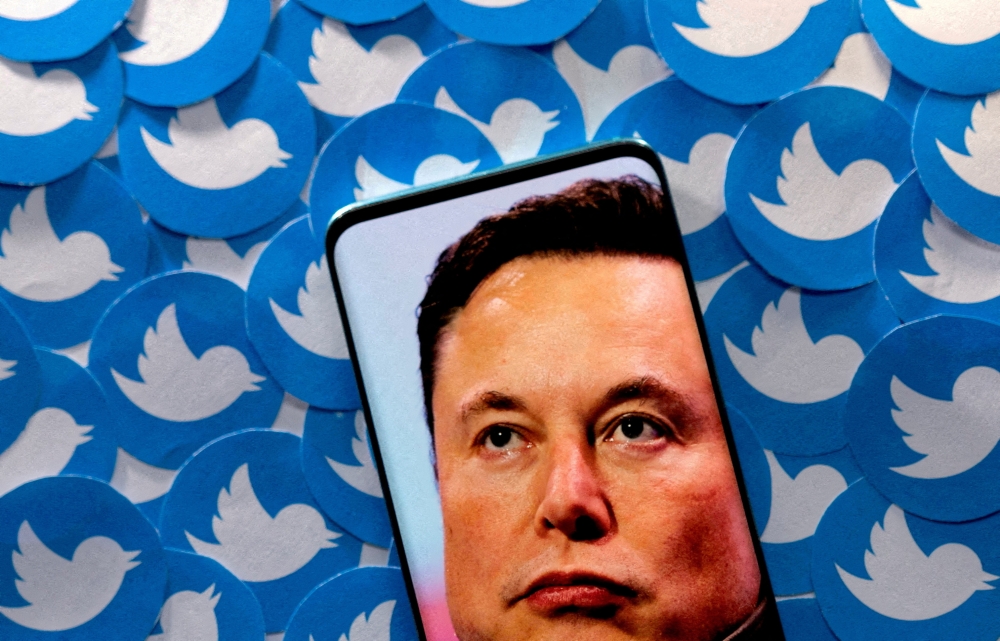An image of Elon Musk is seen on smartphone placed on printed Twitter logos in this picture illustration. (Reuters/Dado Ruvic/Illustration/File Photo)