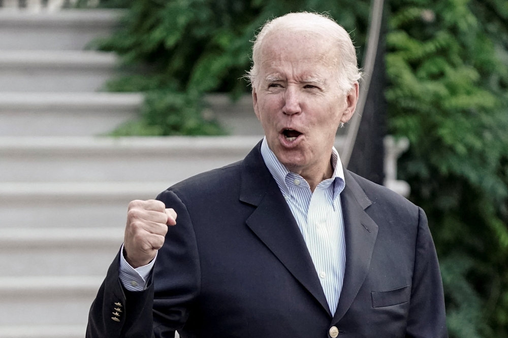 U.S. President Joe Biden gestures to the media as he walks towards Marine One for departure to Rehoboth Beach, Delaware from the South Lawn of the White House in Washington, D.C., U.S. August 7, 2022. REUTERS/Ken Cedeno