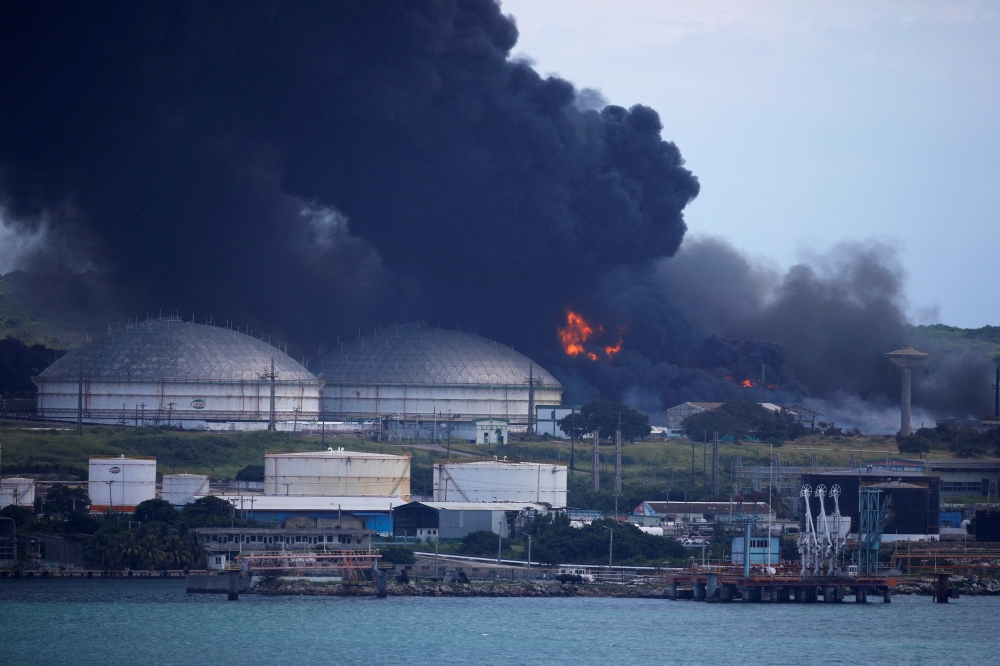 Fire is seen over fuel storage tanks that exploded near Cuba's supertanker port in Matanzas, Cuba, August 7, 2022. (REUTERS/Alexandre Meneghini)