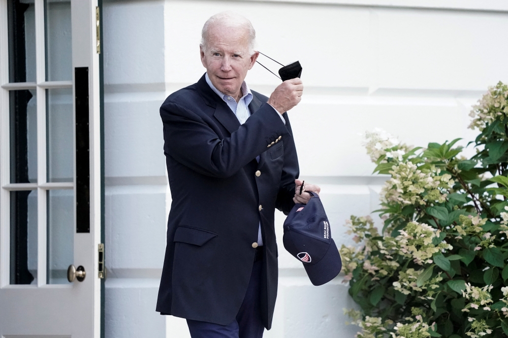 US President Joe Biden takes off his mask as he walks towards Marine One for departure to Rehoboth Beach, Delaware from the South Lawn of the White House in Washington on August 7, 2022. (REUTERS/Ken Cedeno)