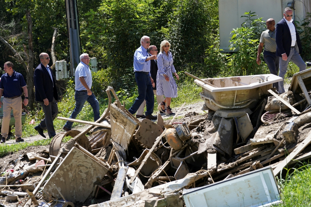 US President Joe Biden and first lady Jill Biden walks through debris while viewing flood damage and response efforts in Lost Creek, Kentucky, US, August 8, 2022. (REUTERS/Kevin Lamarque)