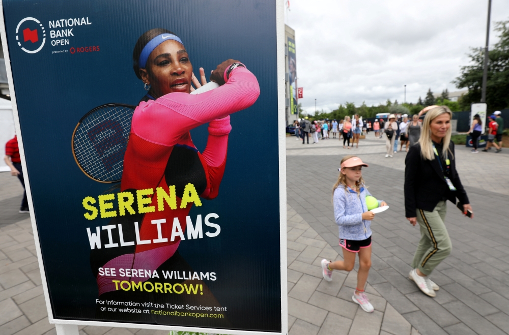 People pass a poster advertising the match of veteran tennis player Serena Williams outside a stadium at the National Bank Open in Toronto, Ontario, Canada August 9, 2022. Reuters/Chris Helgren