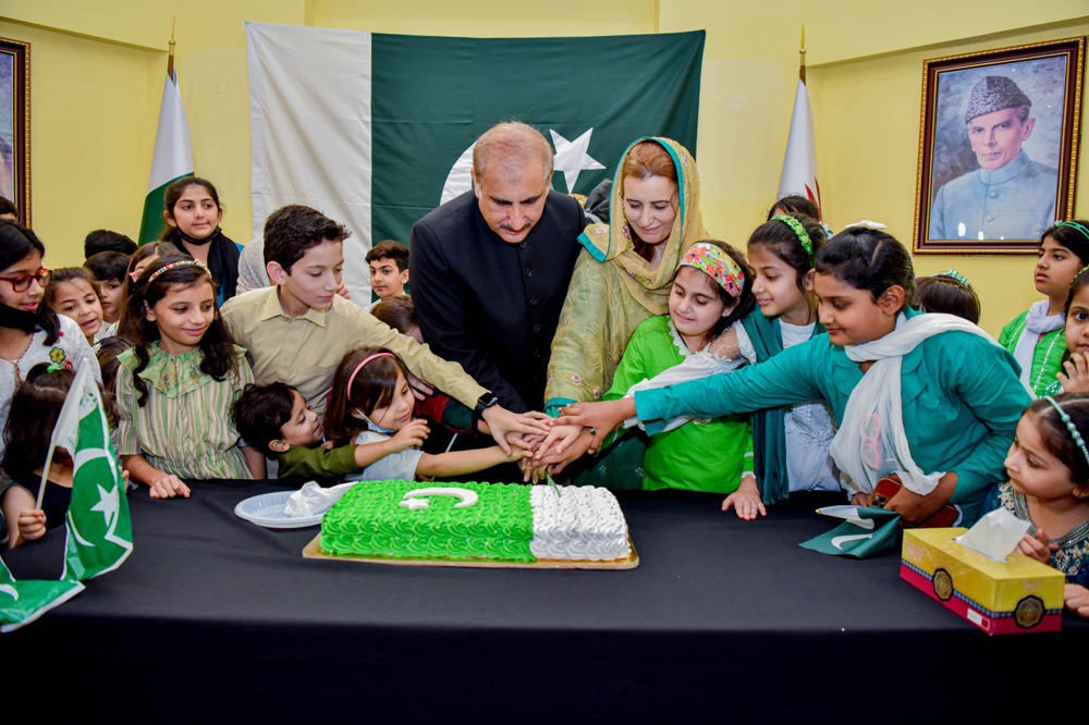 Ambassador H E Syed Ahsan Raza Shah hoisting the national flag and cutting a cake to mark 76th independence day of Pakistan at the Embassy of Pakistan in Doha yesterday. 