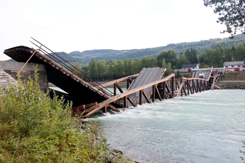Cars are seen over the collapsed bridge over the River Laagen in Gudbrandsdalen, Norway, August 15, 2022. Geir Olsen/NTB via REUTERS