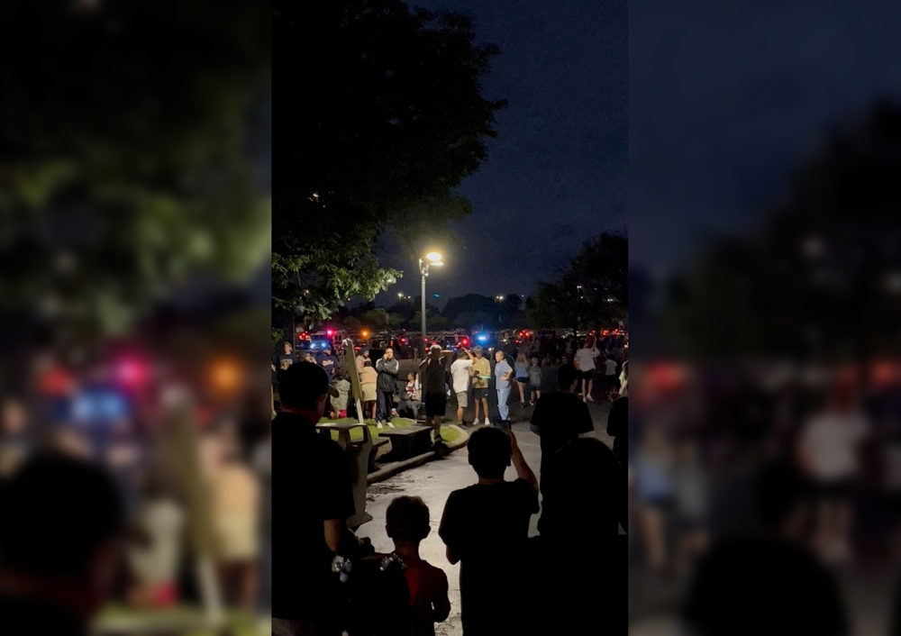 People walk towards emergency vehicles after a shooting at the Six Flags Great America amusement park in Gurnee, Illinois, U.S., August 14, 2022, in this screengrab obtained from a social media video. Jack/via REUTERS