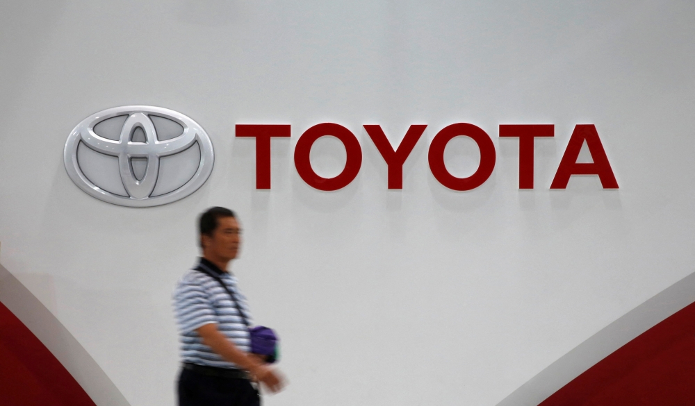 A man walks past Toyota Motor's logo at the company's showroom in Tokyo November 5, 2014. REUTERS/Toru Hanai/File Photo