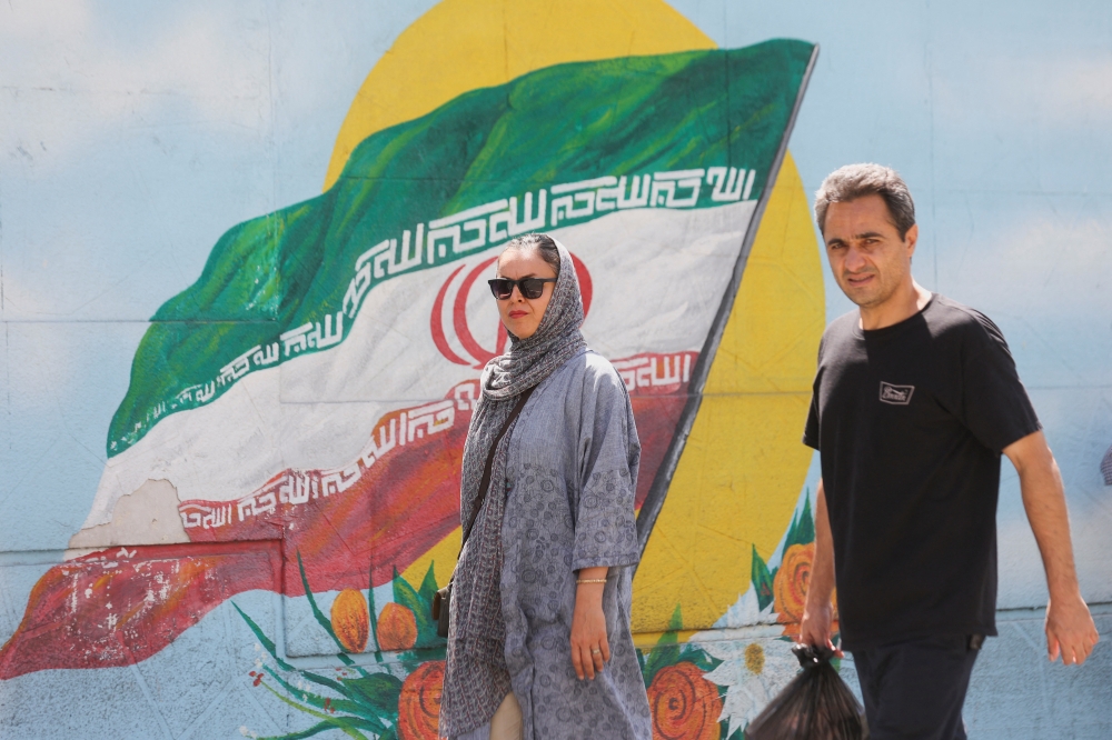 Iranians walk in a street, in Tehran, Iran, August 16, 2022. (Majid Asgaripour/West Asia News Agency via Reuters)