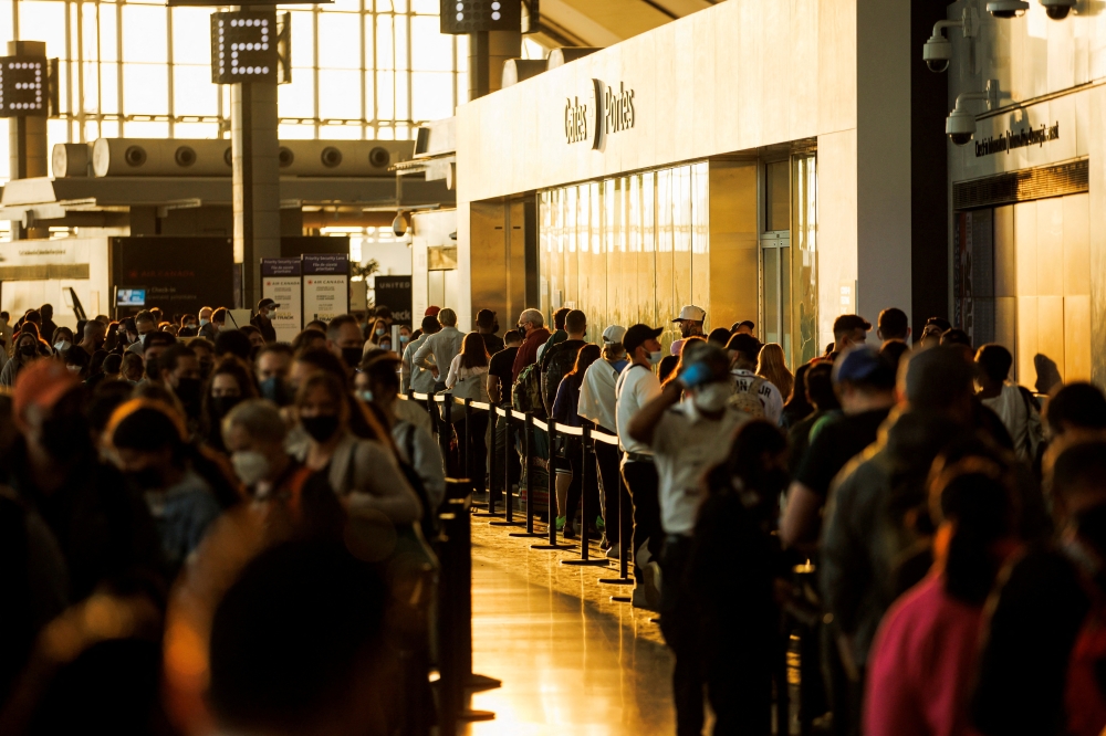 Travellers crowd the security queue in the departures lounge at the start of the Victoria Day holiday long weekend at Toronto Pearson International Airport in Mississauga, Ontario, Canada, May 20, 2022. REUTERS/Cole Burston/File Photo