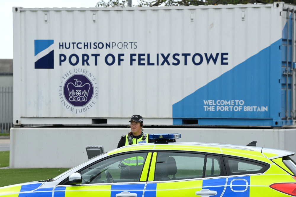 A police officer stands on duty outside an entrance at UK's biggest container port Felixstowe, as workers begin an 8-day strike, in Felixstowe, Britain, August 21, 2022. REUTERS/Toby Melville