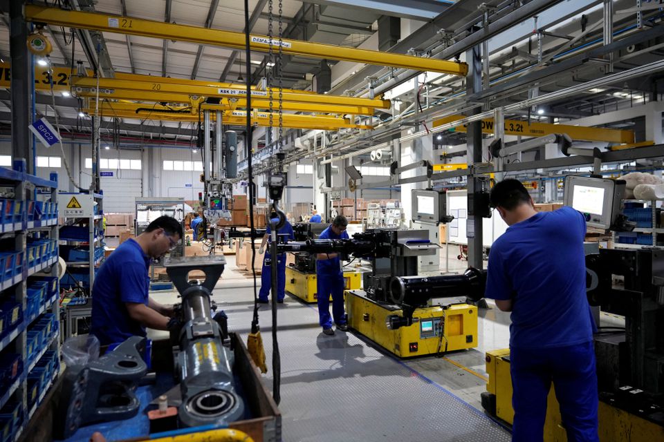 FILE PHOTO:Employees work on the production line of vehicle components during a government-organised media tour to a factory of German engineering group Voith, following the coronavirus disease (COVID-19) outbreak, in Shanghai, China July 21, 2022. REUTERS/Aly Song

