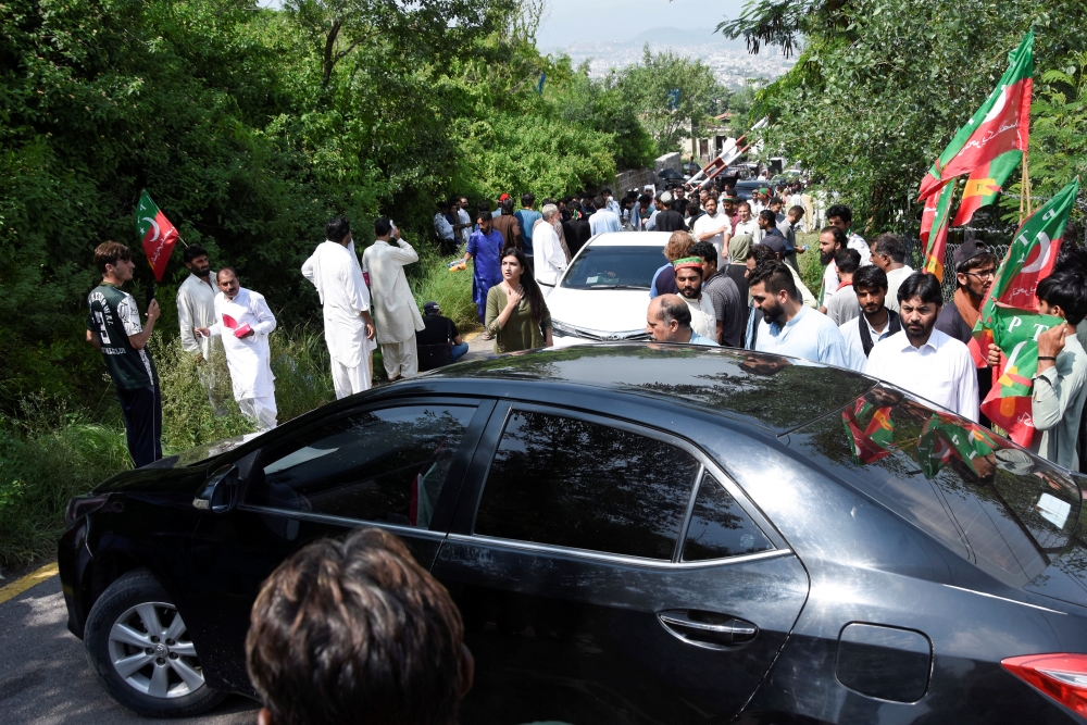 Supporters of former Pakistan's Prime Minister Imran Khan block a road with a car, as they gather to prevent his arrest on anti-terrorism charges, in Islamabad Pakistan, August 22, 2022. (REUTERS/Waseem Khan)