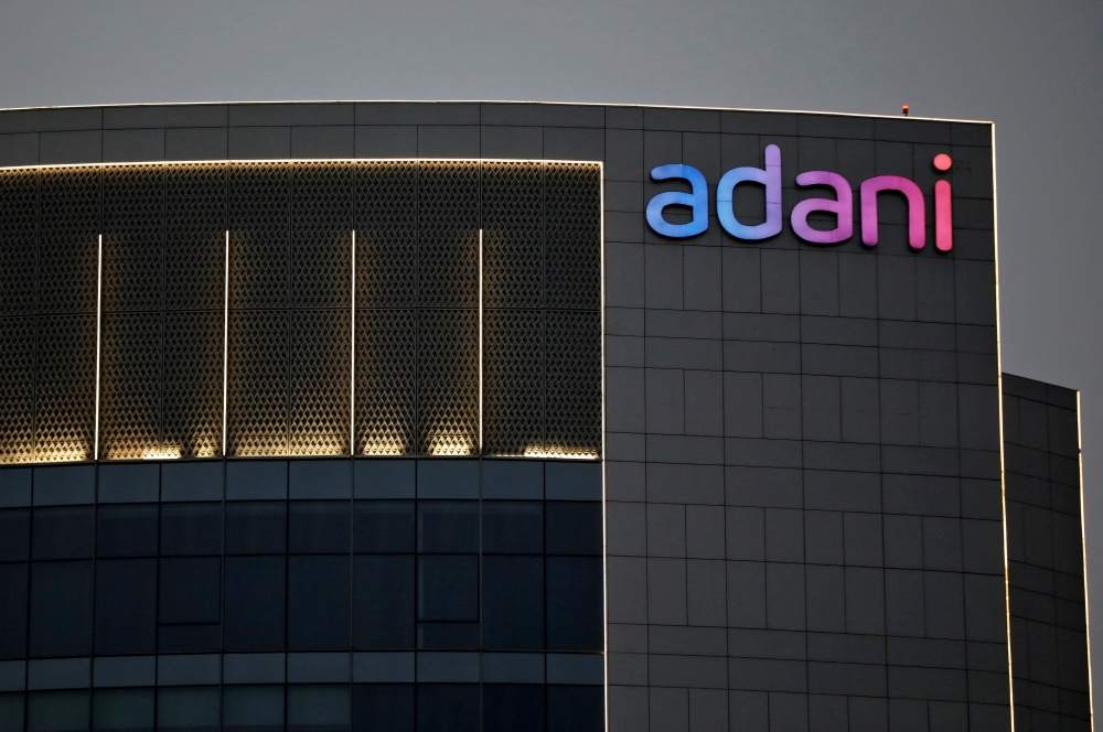 FILE PHOTO: The logo of the Adani Group is seen on the facade of one of its buildings on the outskirts of Ahmedabad, India, April 13, 2021. REUTERS/Amit Dave