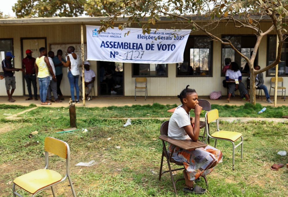 A woman sits outside a voting station after casting her vote during the general election in Cacuaco, Luanda, Angola August 24, 2022. Reuters/Siphiwe Sibeko