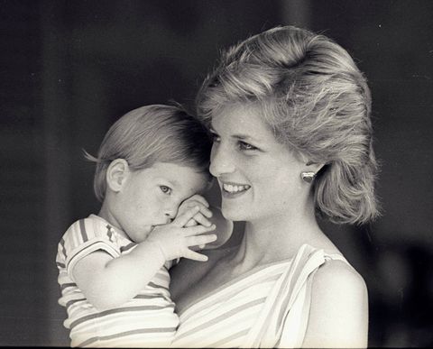 Young Prince Harry tries to hide behind his mother, Britain's Princess Diana, during a morning picture session at Marivent Palace, August 9, 1988. REUTERS/Hugh Peralta/File Photo