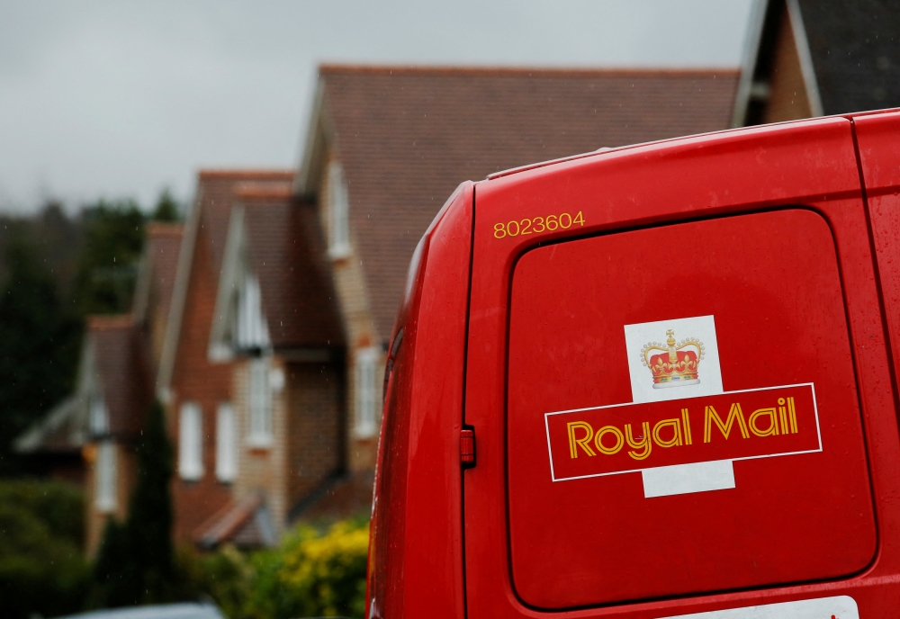 File Photo: A Royal Mail postal van is parked outside homes in Maybury near Woking in southern England, March 25, 2014. (REUTERS/Luke MacGregor)