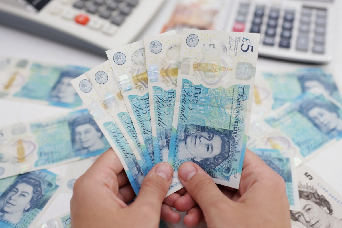 Woman holds British Pound banknotes in this illustration taken on May 30, 2022. REUTERS/Dado Ruvic/Illustration