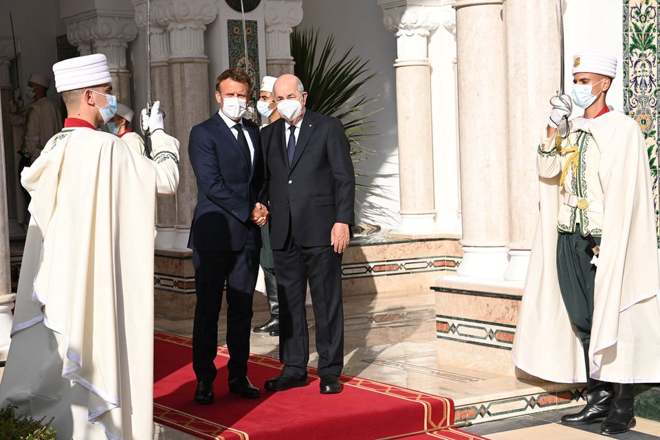 French President Emmanuel Macron shakes hand with Algerian President Abdelmadjid Tebboune at the presidential palace in Algiers, Algeria, on August 25, 2022. Algerian Presidency/Handout via Reuters