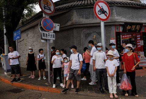 People wear face masks as they stand in a street following a coronavirus disease (COVID-19) outbreak, in Beijing, China, August 3, 2022. REUTERS/Thomas Peter/