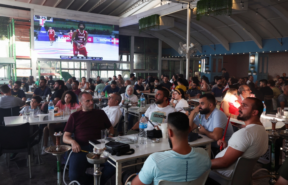 People watch FIBA Basketball World Cup 2023 Asian Qualifiers between Lebanon and India, at a cafe in Dekwaneh, Lebanon, August 29, 2022. (REUTERS/Mohamed Azakir)