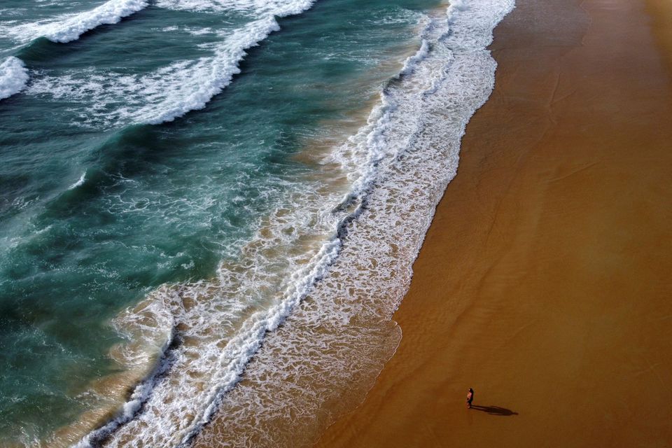 A man walks at the empty Karon beach on Phuket Island, Thailand in April 1, 2021. Picture taken April 1, 2021 with a drone. REUTERS/Jorge Silva/File Photo


