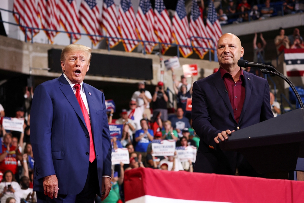 Former U.S. President Donald Trump gestures as Republican Pennsylvania governor candidate Doug Mastriano addresses attendees during a rally in Wilkes-Barre, Pennsylvania, on September 3, 2022.  REUTERS/Andrew Kelly