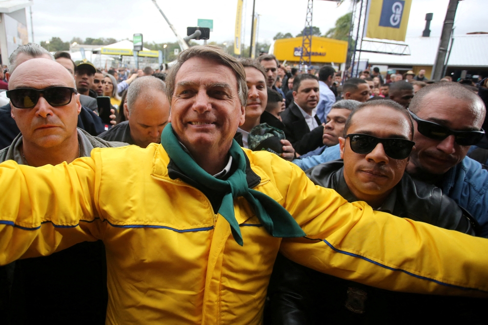 Brazil's President Jair Bolsonaro greets supporters while he is escorted by members of presidential security during the 45th Expointer agricultural fair in Esteio, Brazil, on September 2, 2022. REUTERS/Diego Vara/File Photo