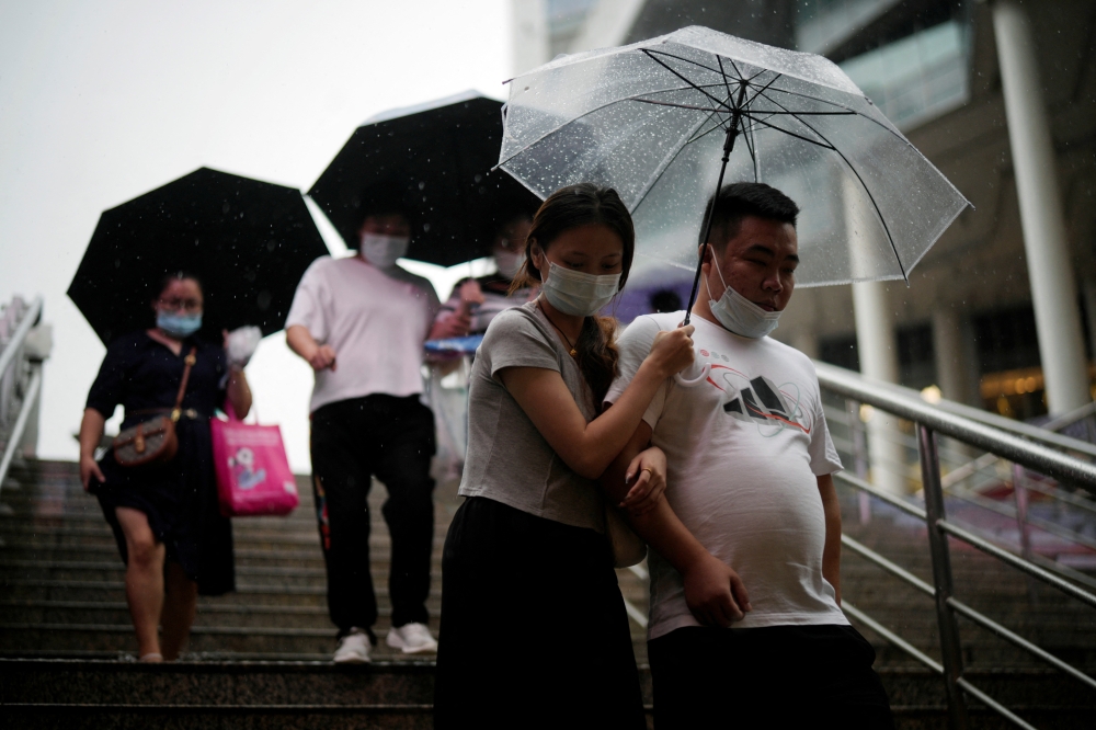 Pedestrians walk with umbrellas amid rain and wind brought by Typhoon Muifa, in Shanghai, China September 14, 2022. Reuters/Aly Song
