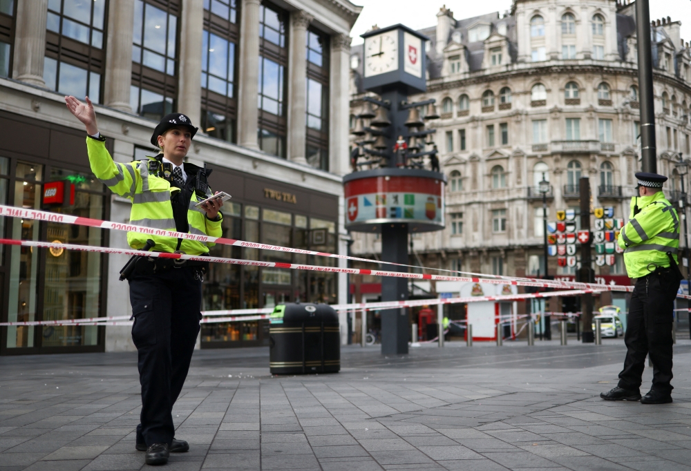 A police officer gestures at the scene where two policemen were stabbed, near Leicester Square, in London, Britain September 16, 2022. REUTERS/Tom Nicholson