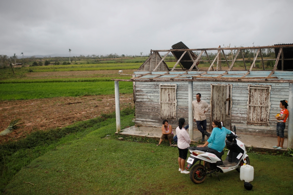 A family speaks in front of their destroyed home in the aftermath of Hurricane Ian in El Cafetal, Cuba, on September 27, 2022. REUTERS/Alexandre Meneghini