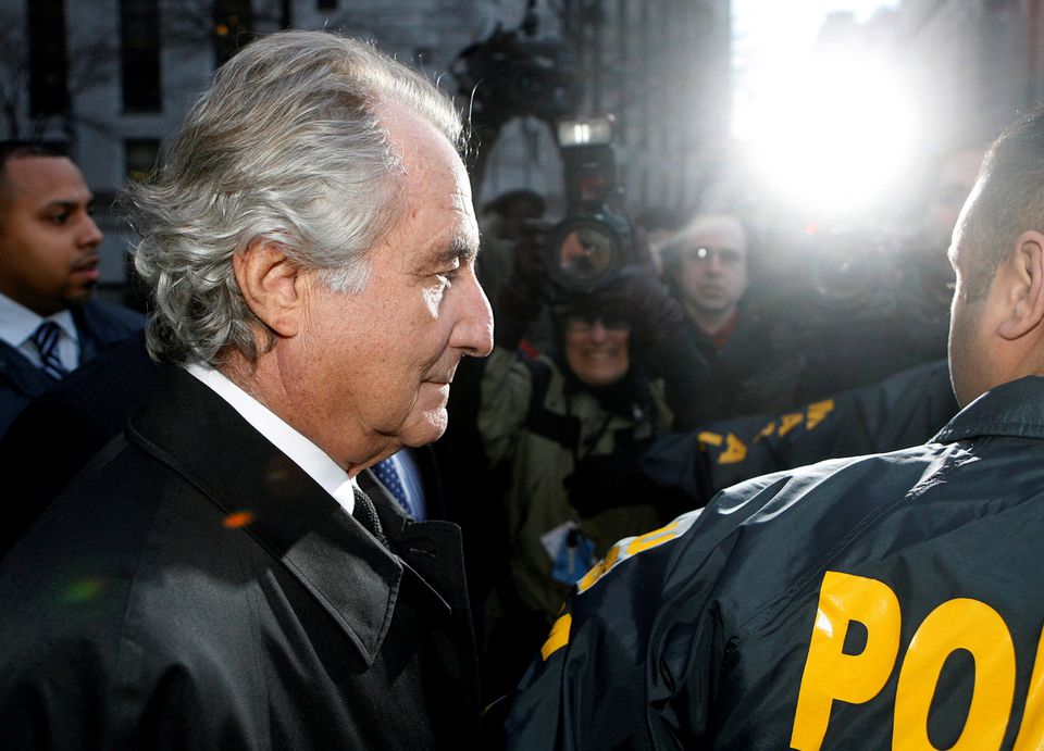 Disgraced financier Bernard Madoff is escorted by police and photographed by the media as he departs US Federal Court after a hearing in New York on January 5, 2009. File Photo / Reuters

