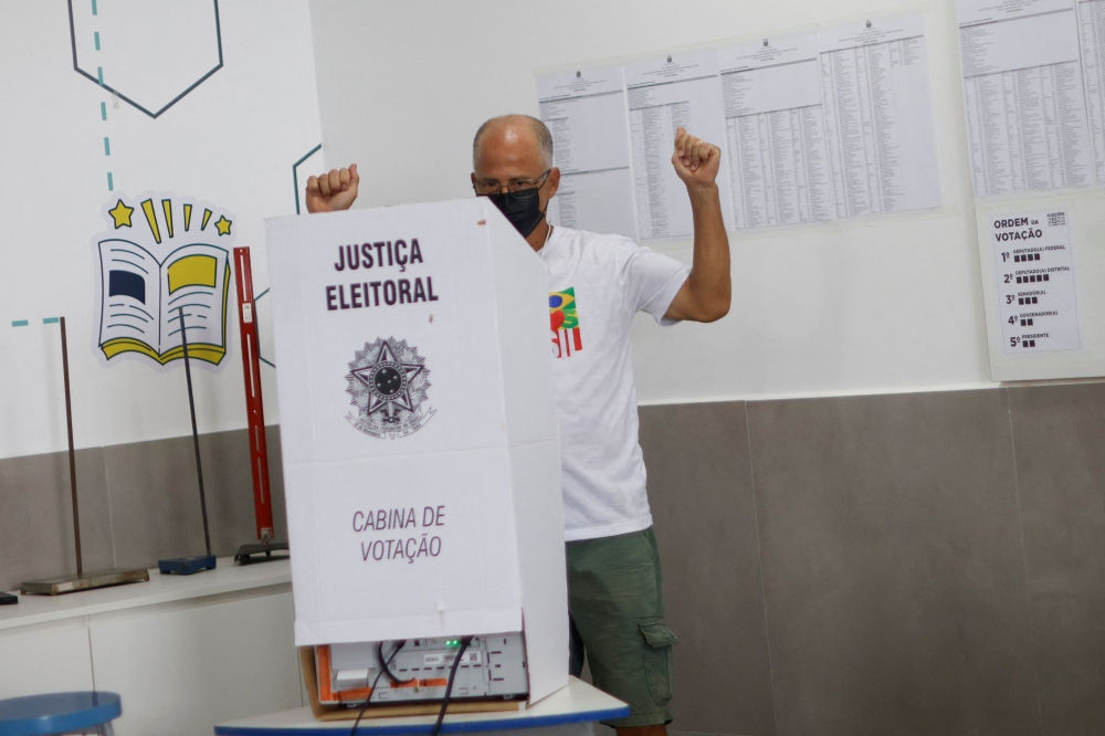 A supporter of Brazil's former President Luiz Inacio Lula da Silva, Charles Bastos, reacts as he casts his vote at a polling station, in Brasilia, Brazil October 2, 2022. Reuters/Adriano Machado