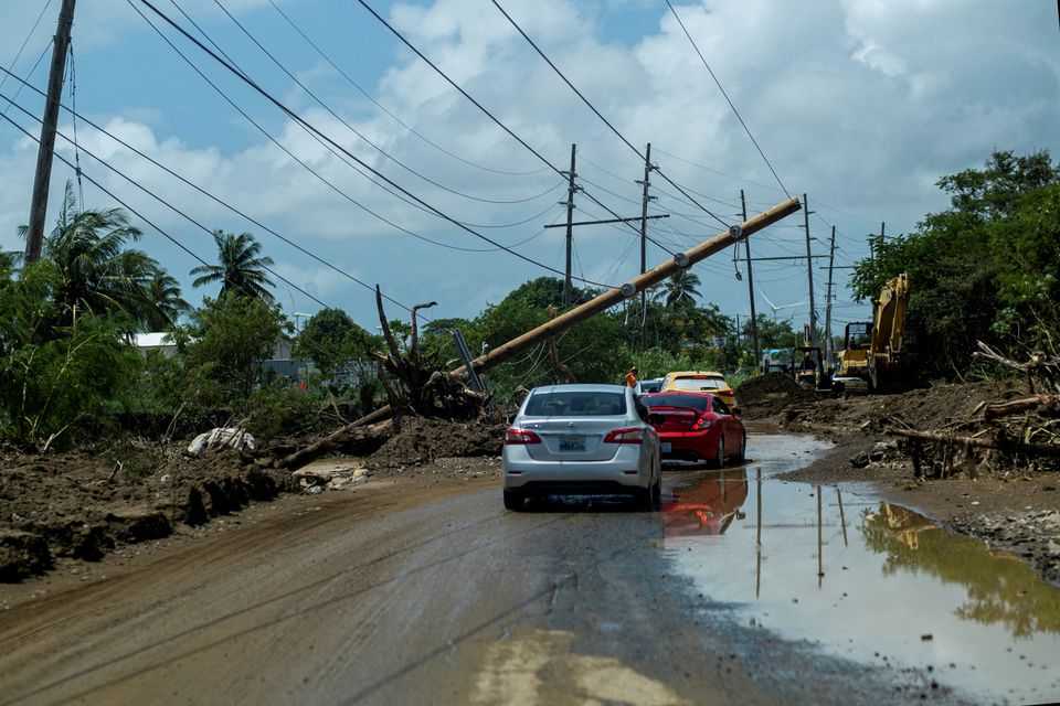 Cars drive under a downed power pole in the aftermath of Hurricane Fiona in Santa Isabel, Puerto Rico September 21, 2022. REUTERS/Ricardo Arduengo/File Photo


