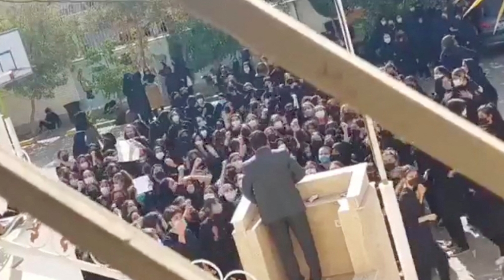 Female protesters react and chant towards a man standing at a podium in Shiraz, Fars province, Iran, on October 4, 2022 in this still image from a video obtained by REUTER
