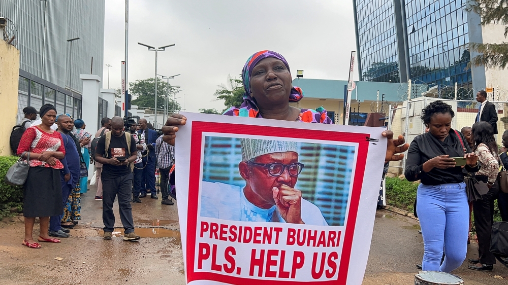 File Photo: A woman is seen with a poster of Nigeria's president Muhammadu Buhari, as relatives of the Kaduna train kidnapped victims protest, following the threat from bandits to kill the victims if ransom demand is not paid, at the ministry of transport in Abuja, Nigeria, July 25, 2022. (REUTERS/Afolabi Sotunde)