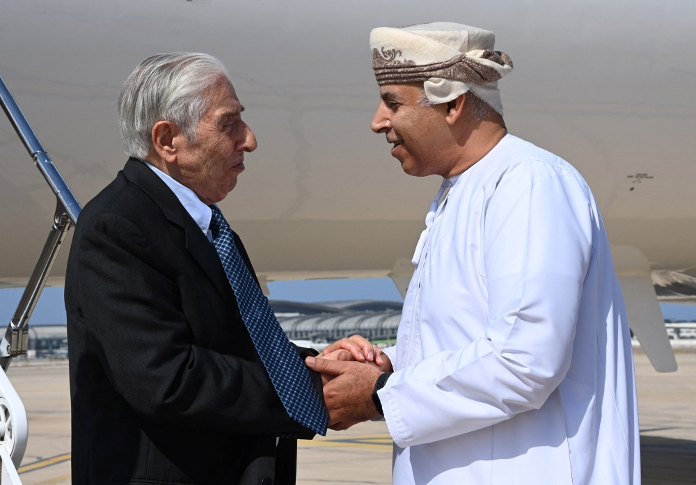 Baquer Namazi, 85, an Iranian American who was jailed in Iran on spying charges, that the United States called baseless, shakes hands with an Omani official upon his arrival in Muscat on October 5, 2022. Oman News Agency/Handout via REUTERS 