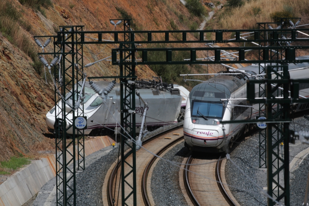 A passenger train passes by a wrecked train engine at the site of a train crash in Santiago de Compostela, northwestern Spain, July 26, 2013. Reuters/Miguel Vidal/File Photo
