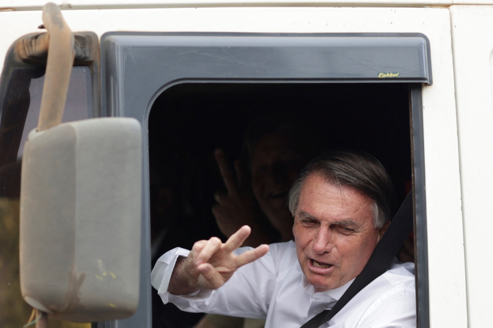 Brazil's President and candidate for re-election Jair Bolsonaro gestures while driving a truck during the taping of a television advertisement for his presidential campaign in Brasilia, Brazil, on October 7, 2022. (REUTERS/Ueslei Marcelino)