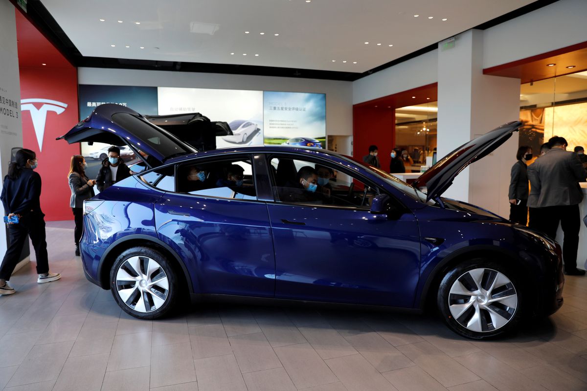 File Photo: Visitors wearing face masks check a China-made Tesla Model Y sport utility vehicle (SUV) at the electric vehicle maker's showroom in Beijing, China, January 5, 2021. (REUTERS/Tingshu Wang)