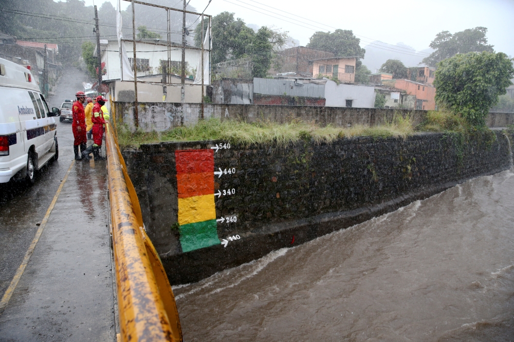 Rescuers observe the level of a river while Tropical Storm Julia hits with wind and rain, in San Salvador, El Salvador, on October 10, 2022. REUTERS/Jose Cabezas